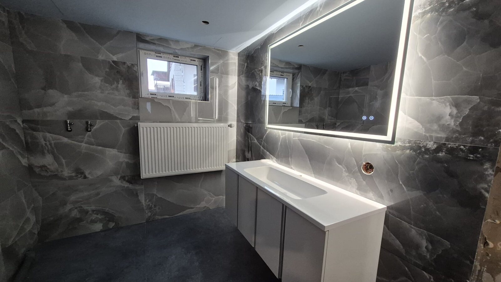 Badezimmer mit LED-Spiegel und Waschtisch