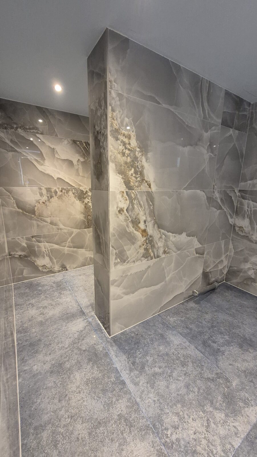 Badezimmer mit gemauerter Trennwand in Steinoptik